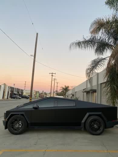 Satin black wrapped Cybertruck photographed at sunset