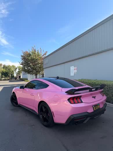 Rear three-quarter view of a pink wrapped Ford Mustang