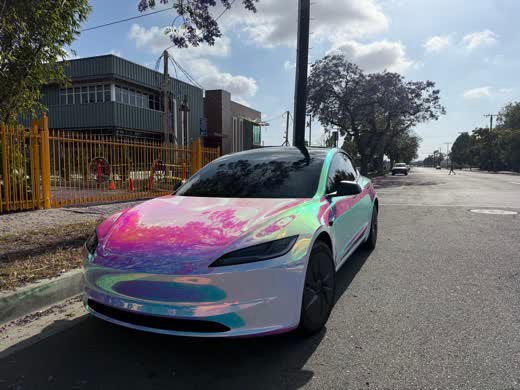 Front view of a Tesla Model 3 in neochrome colour-shift vinyl